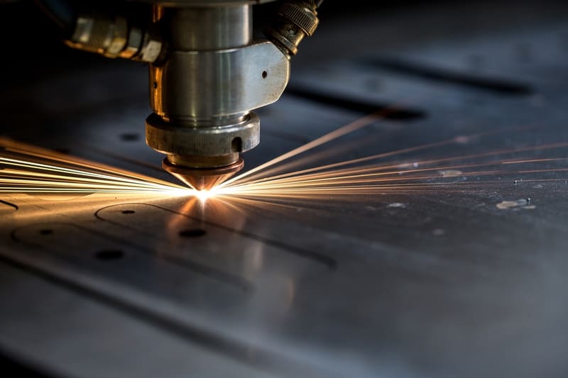 Fibre laser cutting head over sheet steel at the Rexor workshop